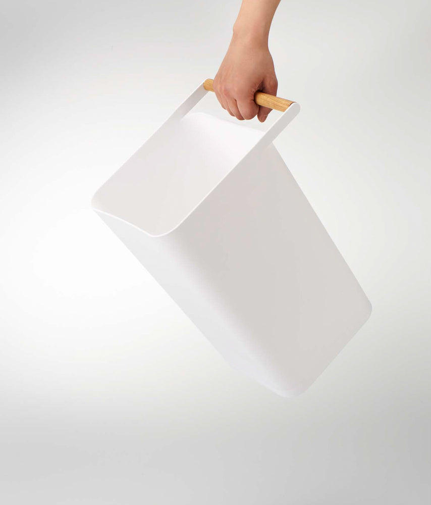 View 5 - White Trash Can held by handle on white background by Yamazaki Home.