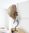 White Over-the-Door Hanger holding hat and jacket on door by Yamazaki Home.