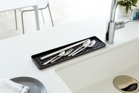 Black Sink Drainer Tray holding silverware on sink countertop by Yamazaki Home. view 11