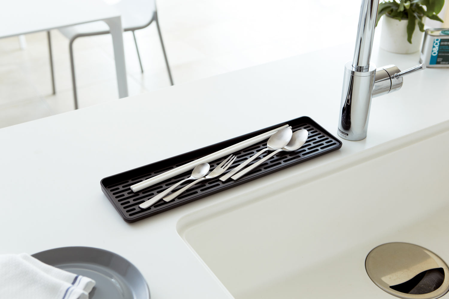 View 11 - Black Sink Drainer Tray holding silverware on sink countertop by Yamazaki Home.