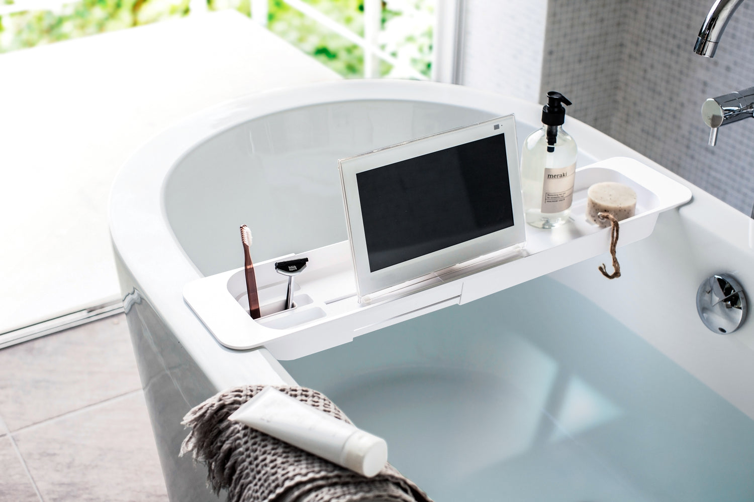 View 5 - White Expandable Bathtub Caddy holding beauty items and tablet by Yamazaki Home.