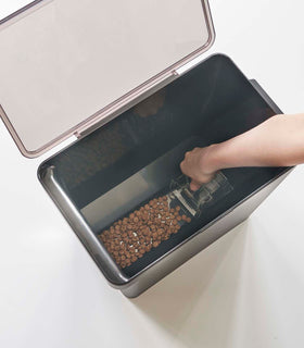 Aerial view of person scooping pet food out of black Airtight Food Storage Container on white background by Yamazaki Home. view 42