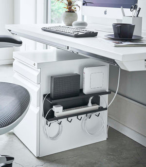 Black Wall-Mount Cable and Router Storage Rack attached to side of cabinet holding router and power cord by Yamazaki Home.