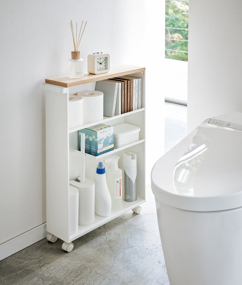 View 2 - Front view of white Rolling Storage Cart holding bathroom items in bathroom by Yamazaki Home.
