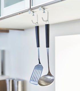 White Undershelf Hangers in kitchen holding cooking utensils by Yamazaki Home. view 2