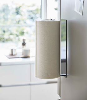 Side view of Black Magnetic Paper Towel Holder holding towels in kitchen by Yamazaki Home. view 11