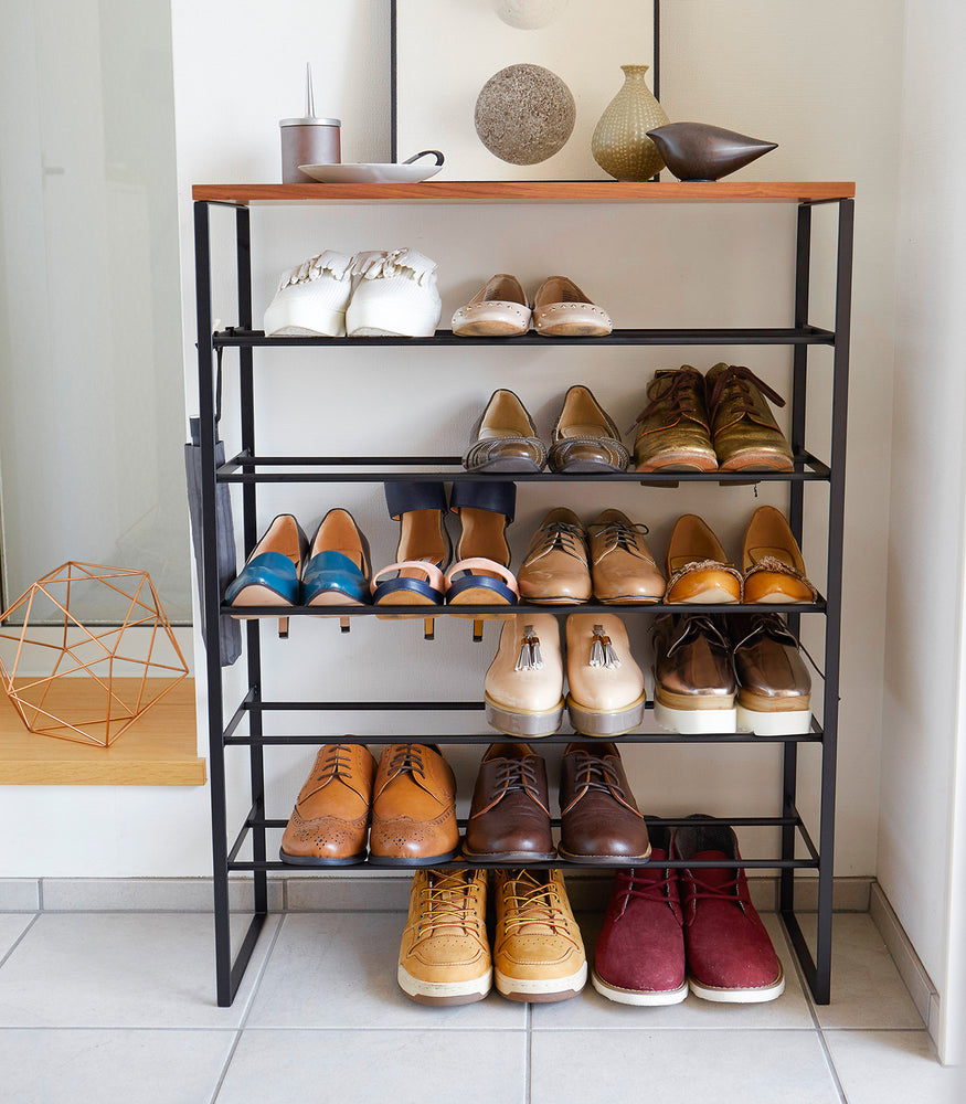 View 12 - Front view of black entryway Shoe Rack holding shoes by Yamazaki Home.