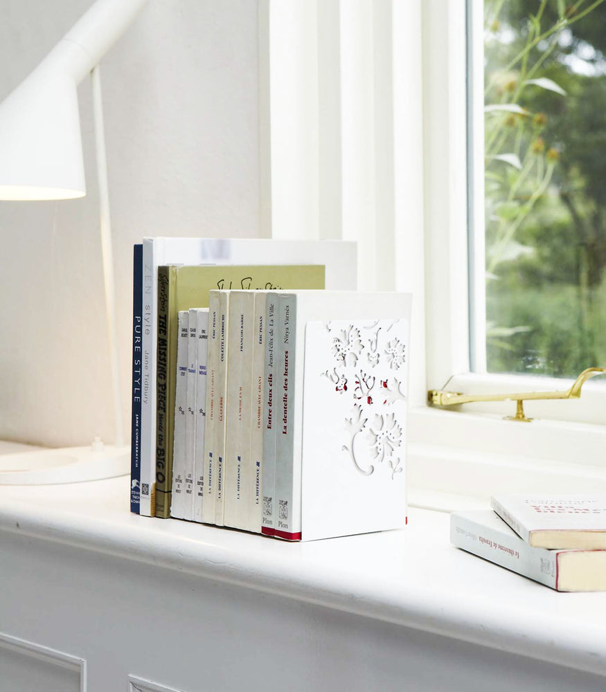 View 2 - White Bookends holding books on shelf by Yamazaki Home.