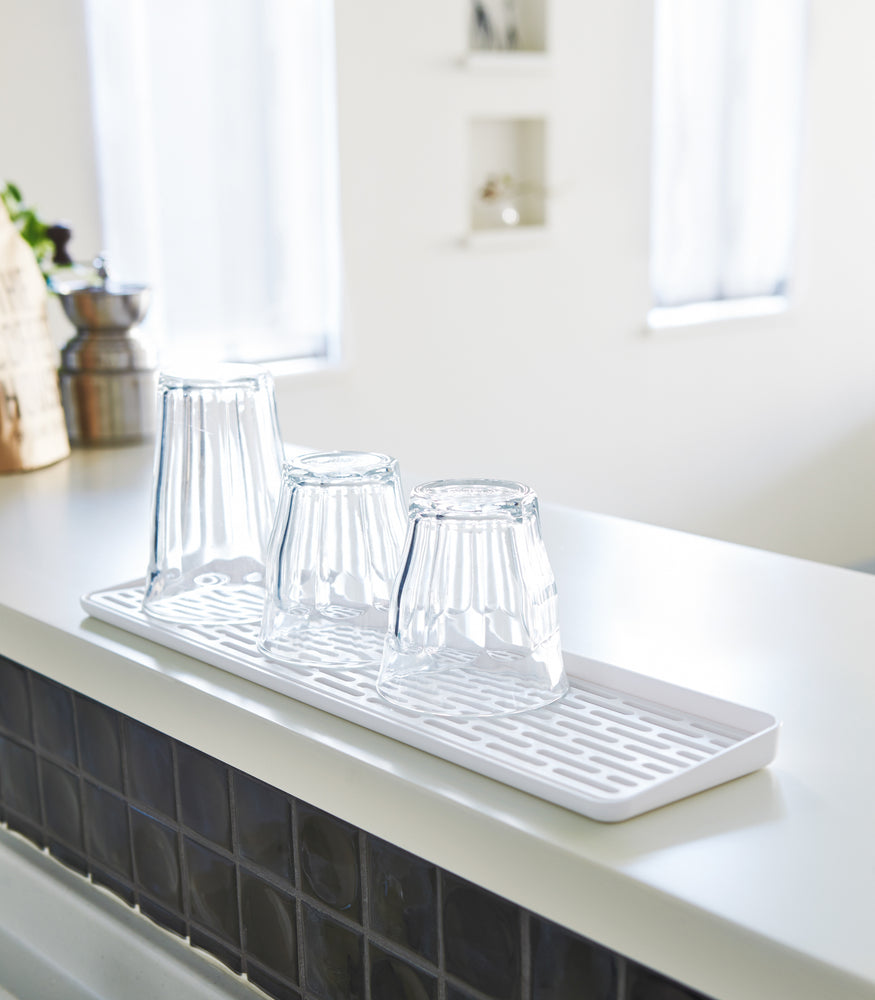 View 3 - White Sink Drainer Tray holding glasses by Yamazaki Home.