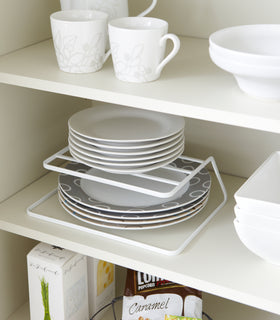White Dish Riser holding plates on shelf by Yamazaki Home. view 2