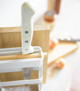 Close up view of white Knife & Cutting Board Stand holding knife and cutting board by Yamazaki Home. view 6