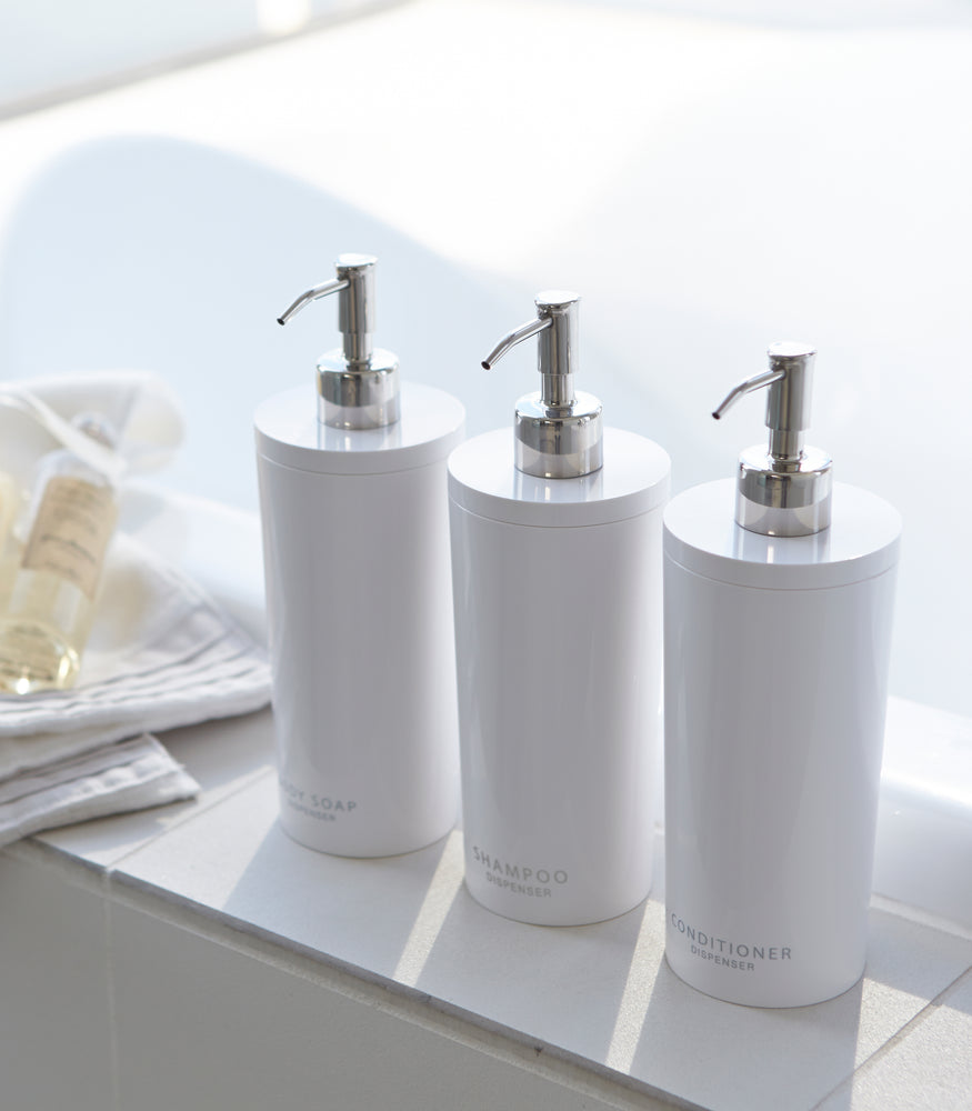 View 3 - Aerial view of white Shampoo Dispenser between Body Soap and Conditioner Dispenser in bathroom by Yamazaki Home.