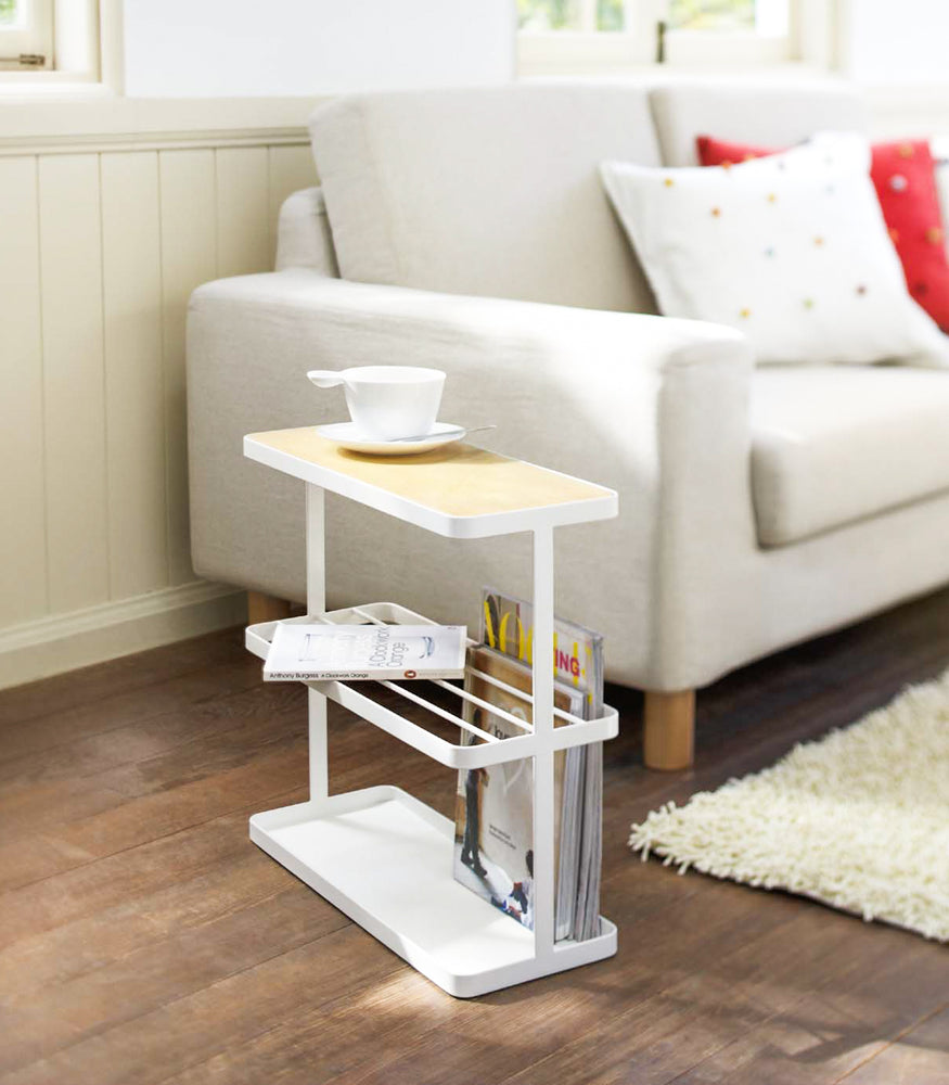 View 2 - White End Table displaying magazines and cup in living room by Yamazaki Home.