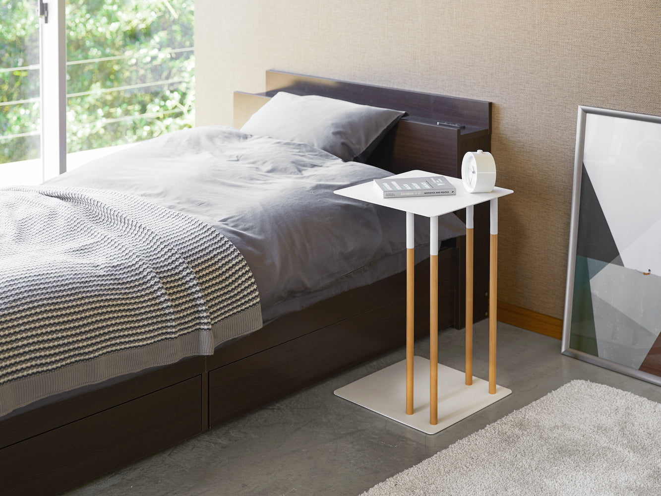 View 4 - White C Side Table displaying book and coffee in bedroom by Yamazaki Home.