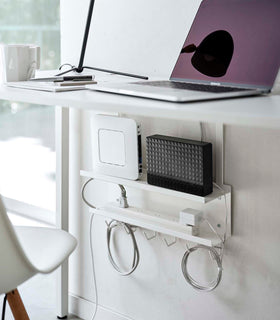 White Wall-Mount Cable and Router Storage Rack holding routers and power cord under desk by Yamazaki Home. view 2