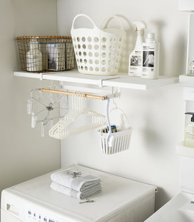 White Undershelf Hanger in laundry room holding laundry accessories by Yamazaki Home. view 2