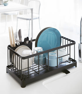 Front view of black Dish Rack holding dinnerware positioned next to sink by Yamazaki Home. view 13