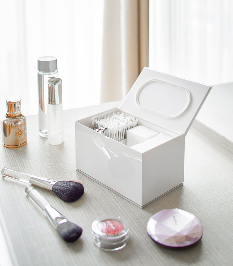 Open white Skincare Organizer holding cotton tips, cotton pads and nail clippers by Yamazaki Home.