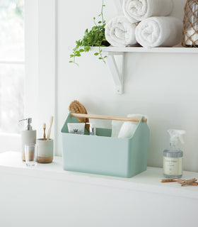 Front view of blue Storage Caddy containing beauty items in bathroom by Yamazaki Home. view 11