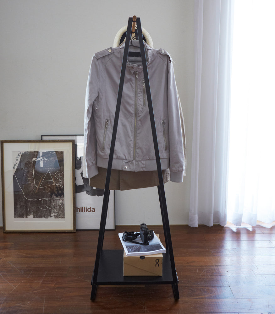 View 7 - Side view of black Freestanding Garment Rack displaying clothes by Yamazaki Home.