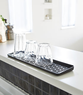 Black Sink Drainer Tray holding glasses by Yamazaki Home. view 8