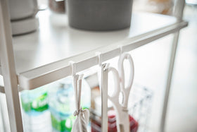 Close up of white Rolling Utility Cart hooks holding kitchen utensils by Yamazaki Home. view 6