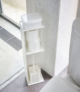 Yamazaki Home white Toilet Organizer holding wet wipe case, toilet paper, and toilet brush in bathroom. view 3