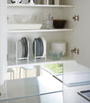 White Dish Storage Rack holding plates in kitchen cabinet by Yamazaki Home.