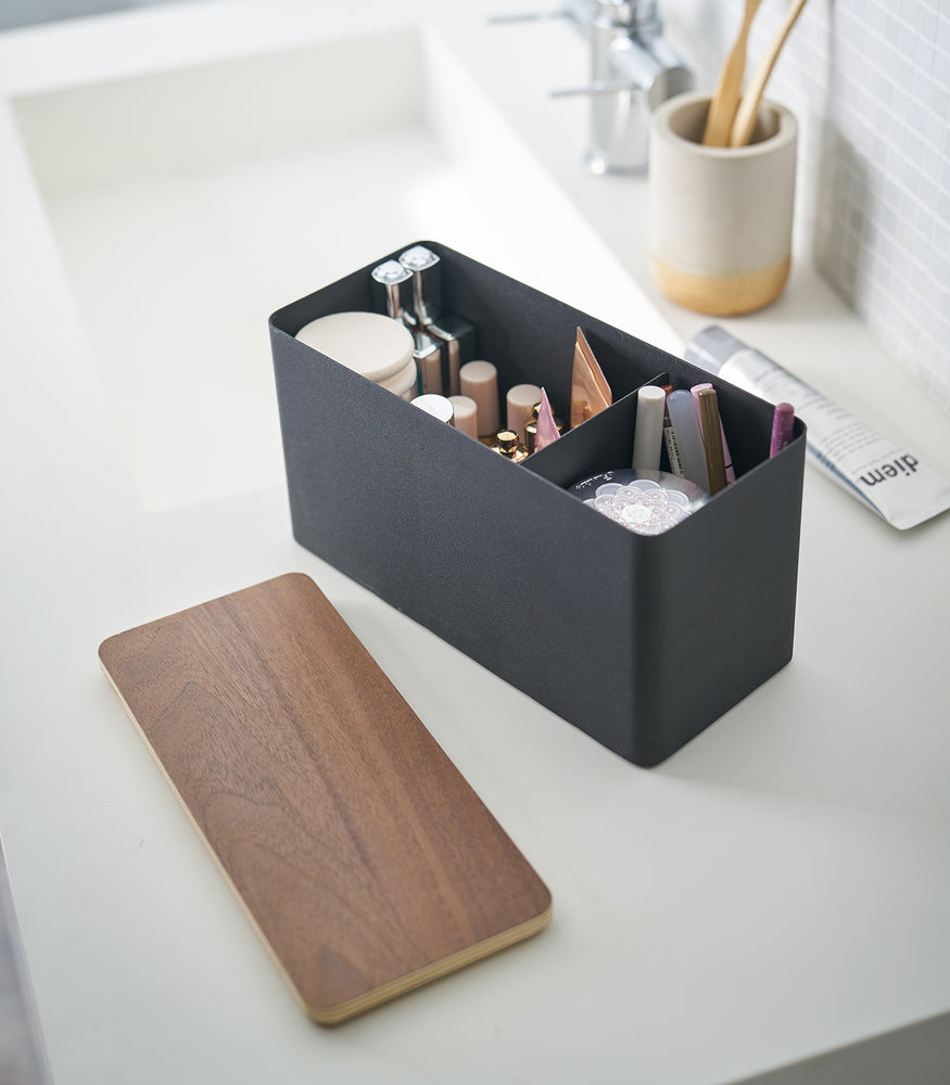 View 12 - Black Countertop Organizer holding makeup products with cover off on sink countertop by Yamazaki Home.