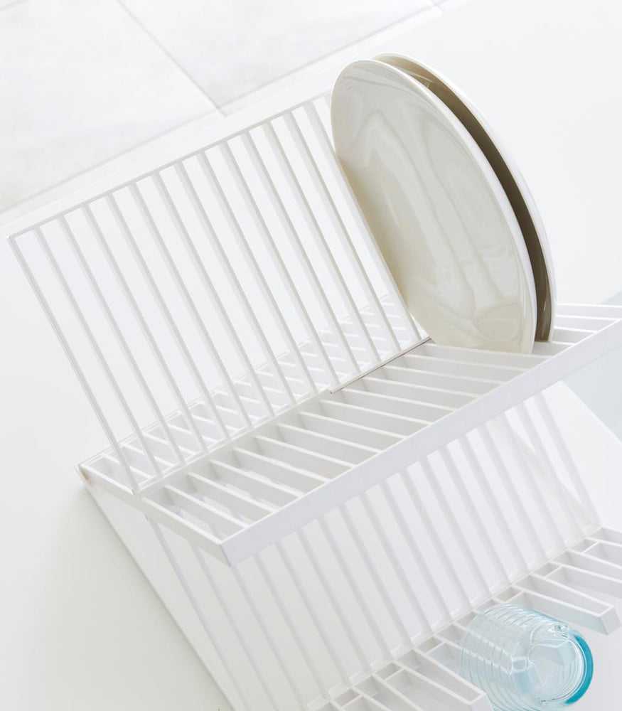 View 4 - Aerial view of white X-Shaped Dish Rack holding plates and cups on white surface by Yamazaki Home.