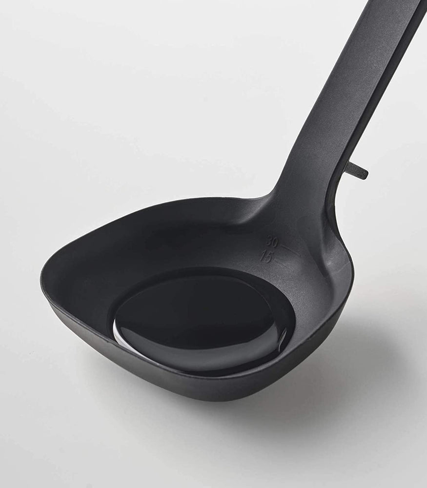 View 6 - Cloes up view of black Floating Ladle on white background by Yamazaki Home.
