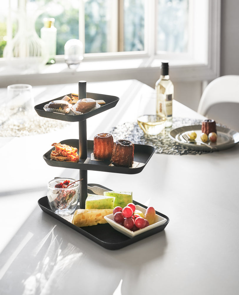View 7 - Black Serving Stand holidng fruit and desserts on dining room table by Yamazaki Home.
