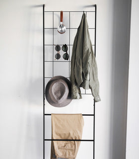 Front view of black Leaning Ladder with Grid Panel displaying clothing and accessories by Yamazaki Home. view 11