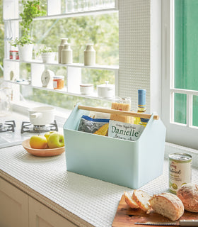 Blue Storage Caddy holding food and drink items on kitchen countertop by Yamazaki Home. view 10
