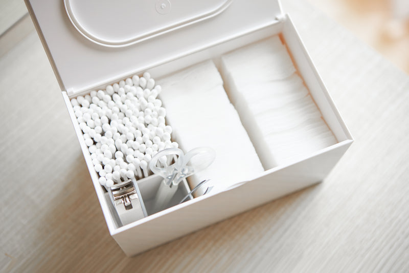Aerial view of white Skincare Organizer holding cotton pads, cotton tips, and nail utensils by Yamazaki Home.