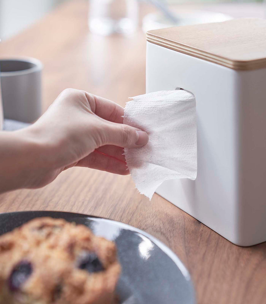 View 6 - Person removing paper from white toilet paper holder on tabletop by Yamazaki Home.