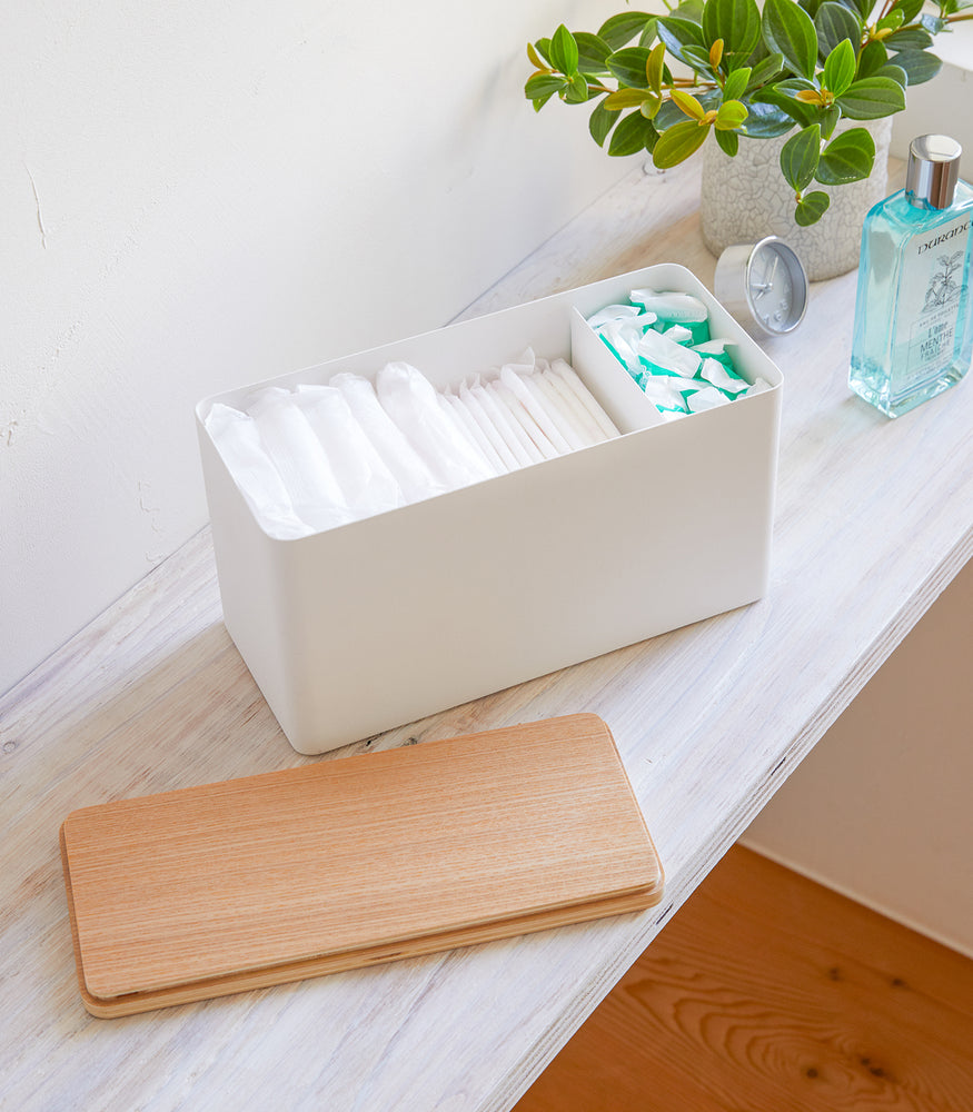 View 3 - White Countertop Organizer holding diapers and products with cover off on shelf by Yamazaki Home.