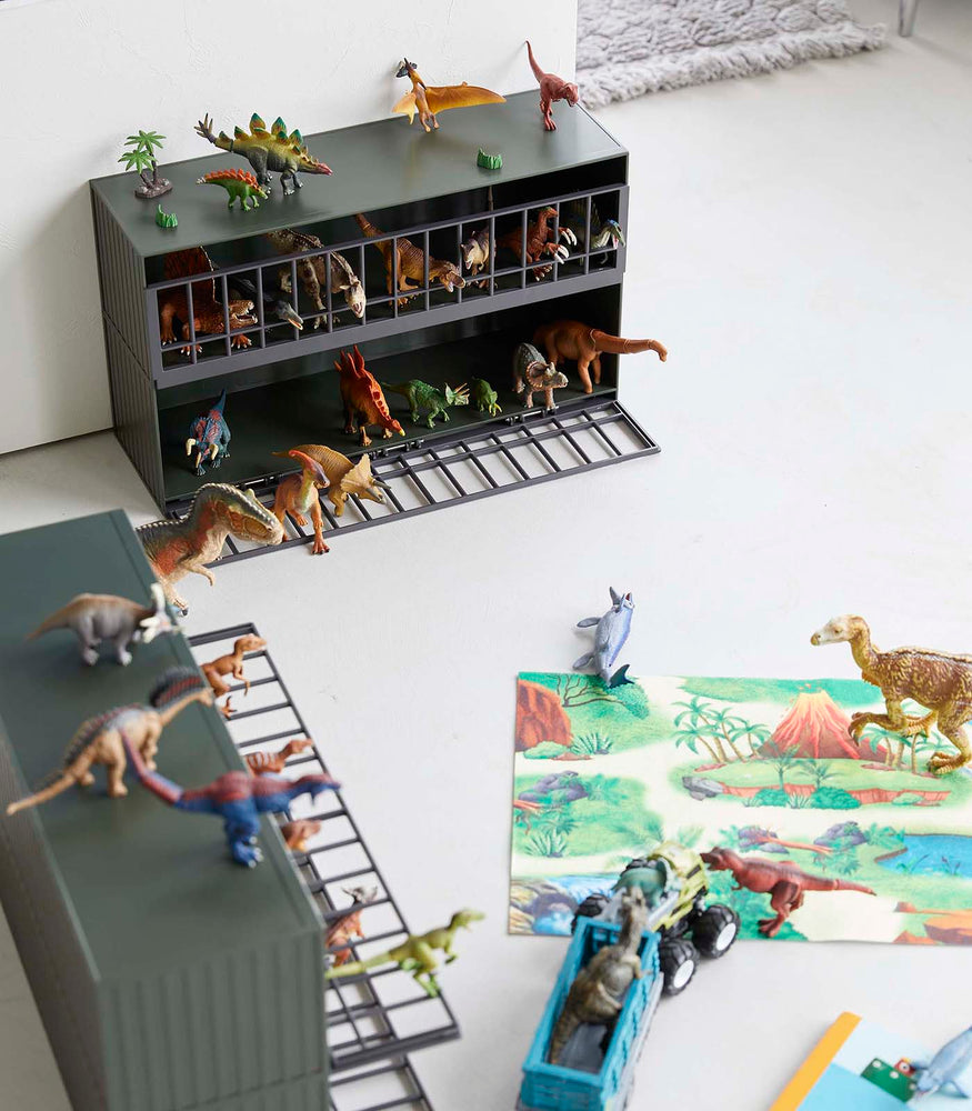 View 14 - Aerial view of two dark green Black Two-Tier Toy Dinosaur and Animal Storage Racks in living room play area holding toy dinosaurs by Yamazaki Home.

