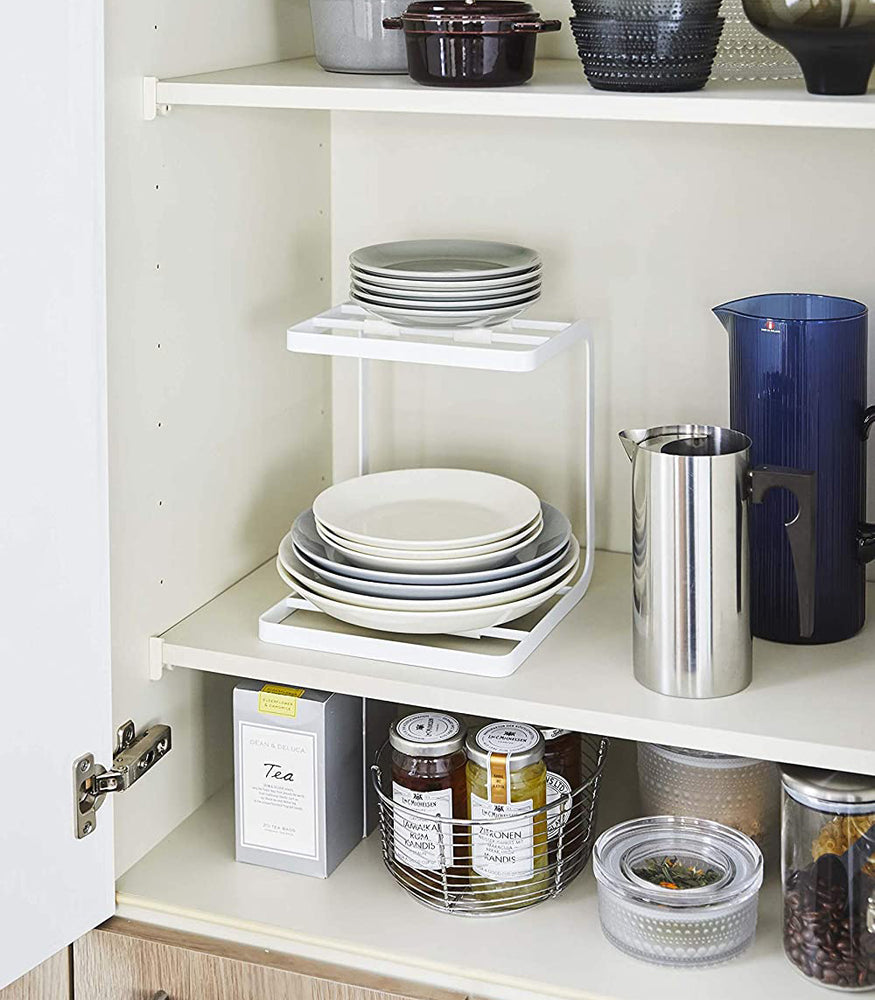 View 4 - White Pot Holder holding plates in kitchen cabinet by Yamazaki Home.