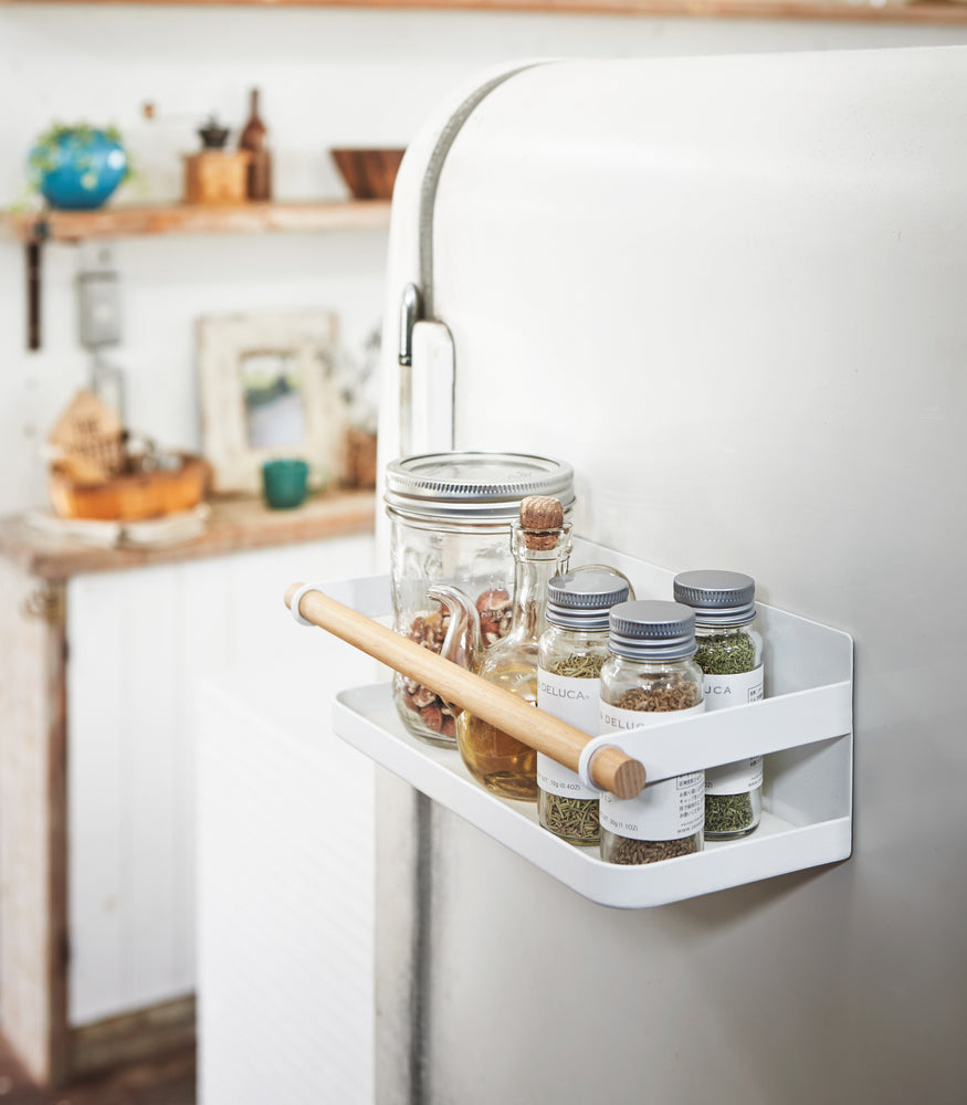 View 3 - White Magnetic Storage Caddy holding spices and vinegar in kitchen by Yamazaki Home.