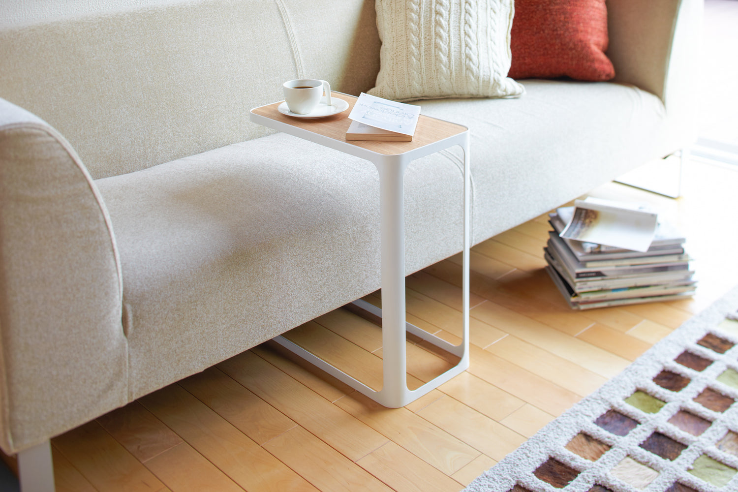 View 3 - White C Side Table displaying coffee cup and book in living room by Yamazaki Home.