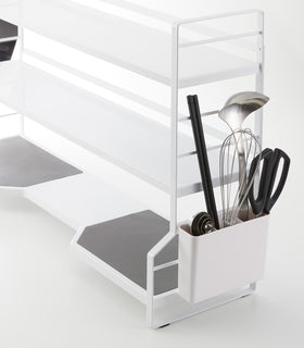 Close up view of white countertop 3-shelf rack with a cutlery holder. view 4