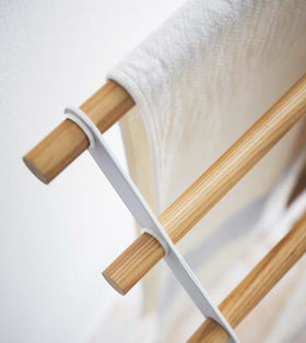 Aerial close up corner view of Bath Towel Rack holding towel on white background by Yamazaki Home. view 5