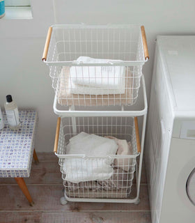 Front aerial view of white Laundry Wagon and Basket holding clothes and towels in laundry room by Yamazaki Home. view 4