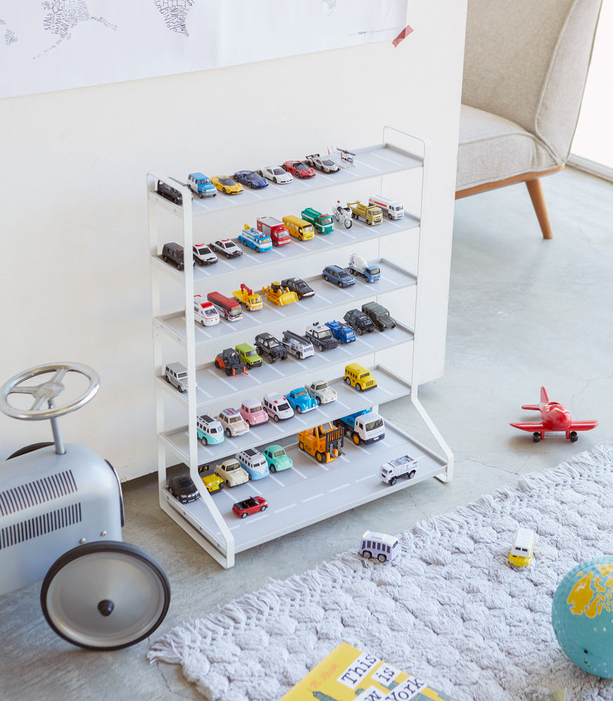 View 2 - White Kids' Parking Garage displaying toy trains and cars in playroom by Yamazaki Home.