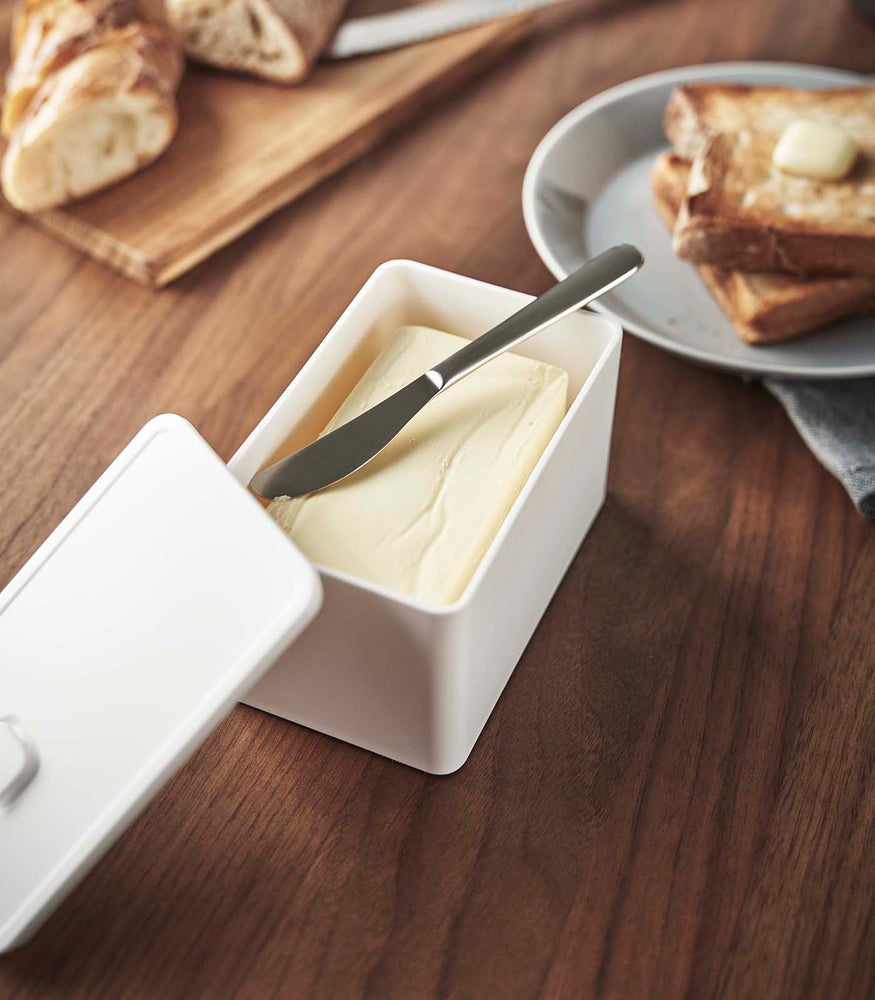 View 4 - White Vacuum-Sealing Butter Dish holding butter on table by Yamazaki Home.