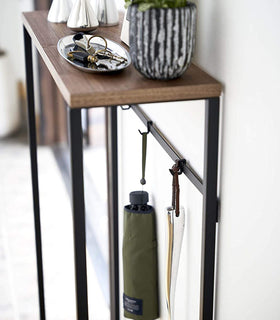 Close up view of Narrow Entryway Console Table holding keys and umbrellas.  view 14