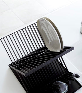 Aerial view of Black X-Shaped Dish Rack holding plates and cups by Yamazaki Home. view 10