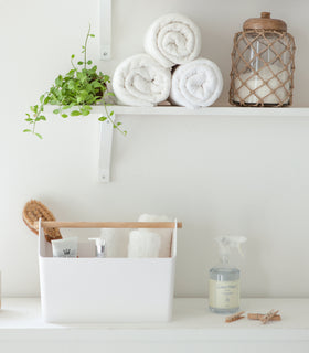 Front view of white Storage Caddy holding towels and bath items by Yamazaki Home. view 5