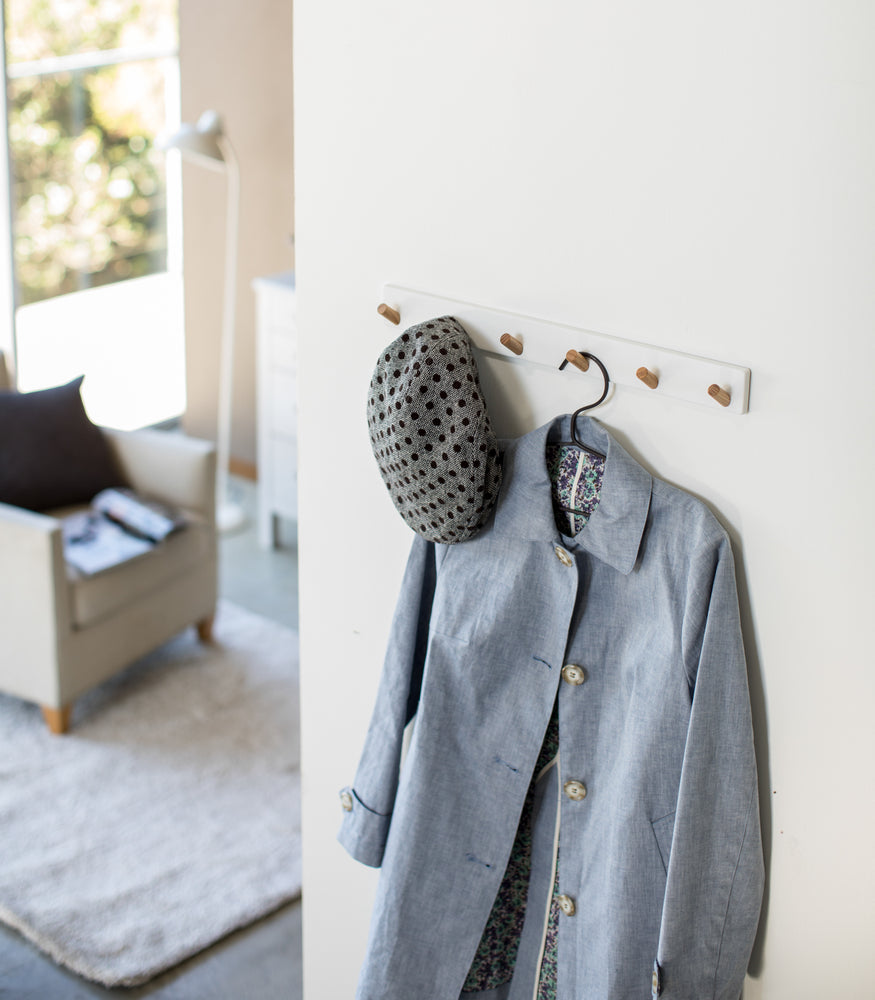 View 2 - White Wall-Mounted Coat Hanger displaying hat and jacket by Yamazaki Home.